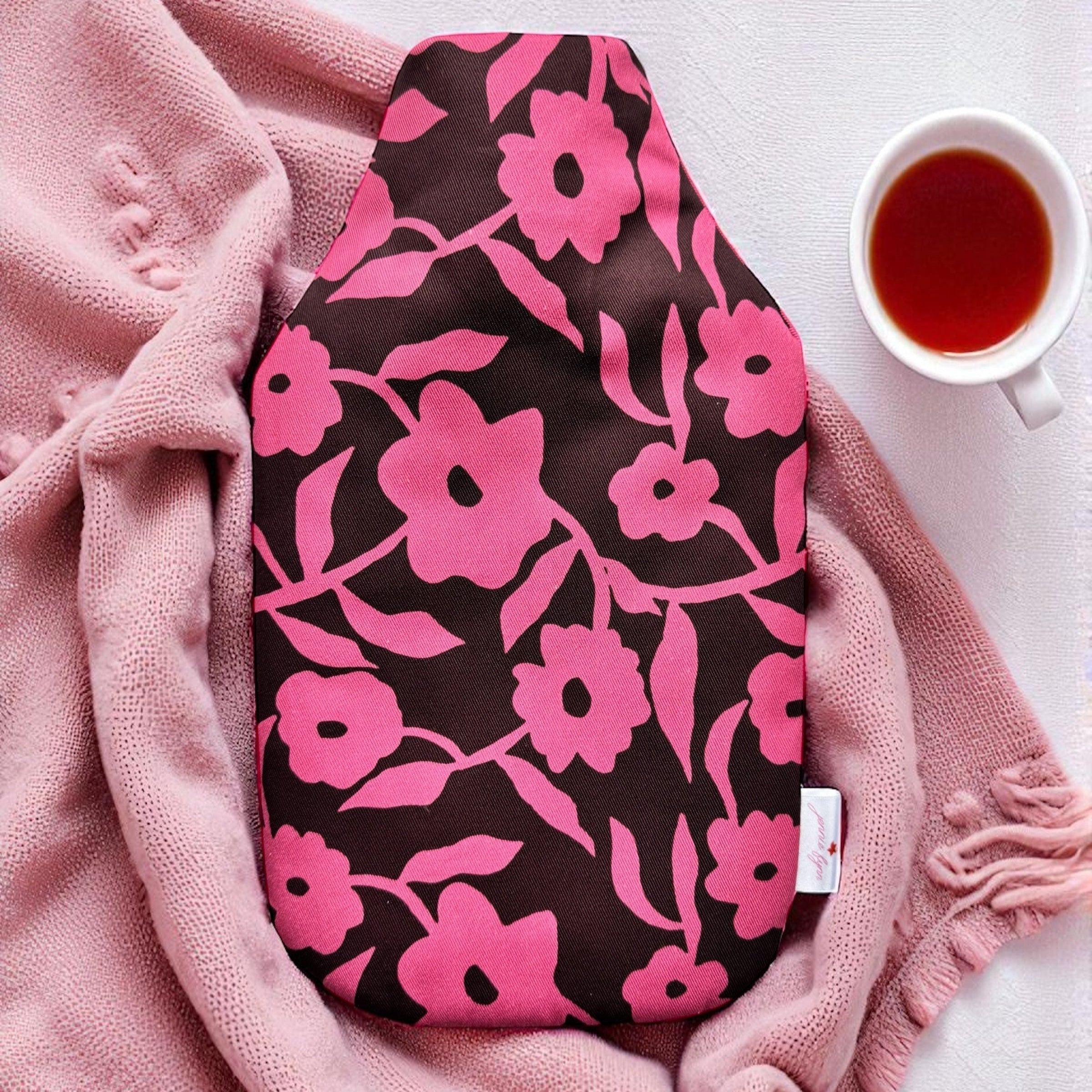 Pink and brown floral hot water bottle on pink blanket